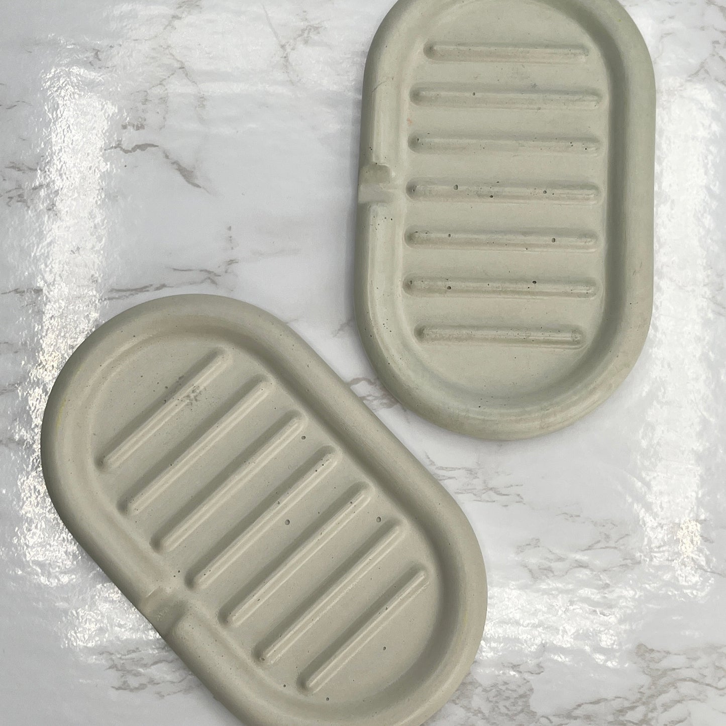 Hand poured self draining concrete soap dish in a cream color to help keep soap bars dry.