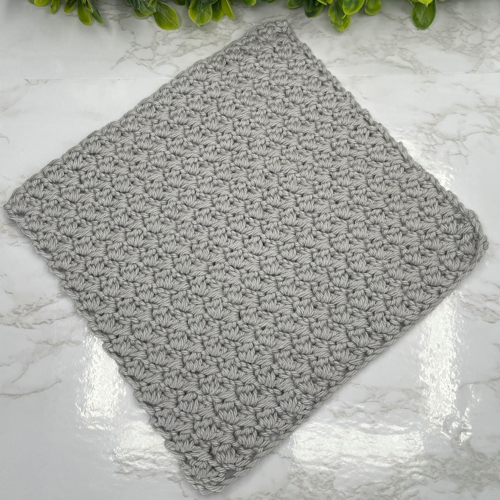 A handmade, crocheted 8 inch square washcloth.