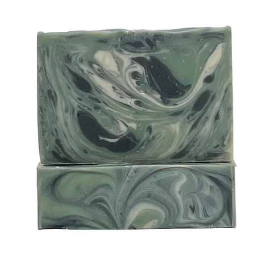 Into the Woods natural evergreen scent, ocean water soap bar enriched with coconut milk and shea butter and scented with woodsy essential oils with black, green and white swirls on a white background by Seagrass Soap Co.