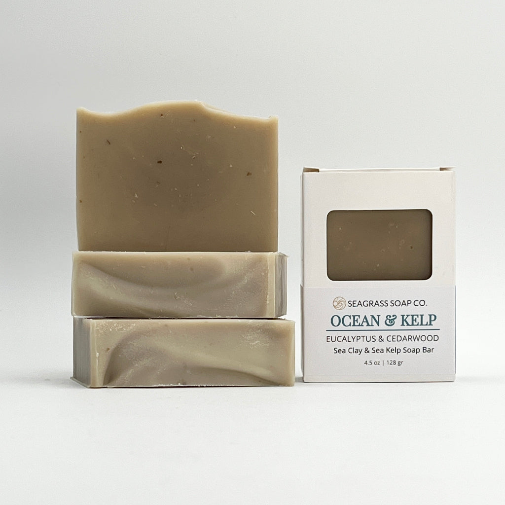 Three bars of Ocean & Kelp soap from Seagrass Soap Co. with their packaging on a white background.