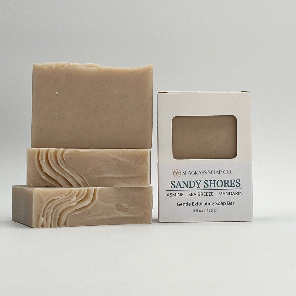 Three Sandy Shores soap bars and box packaging on a white background showing soap top wavy design.