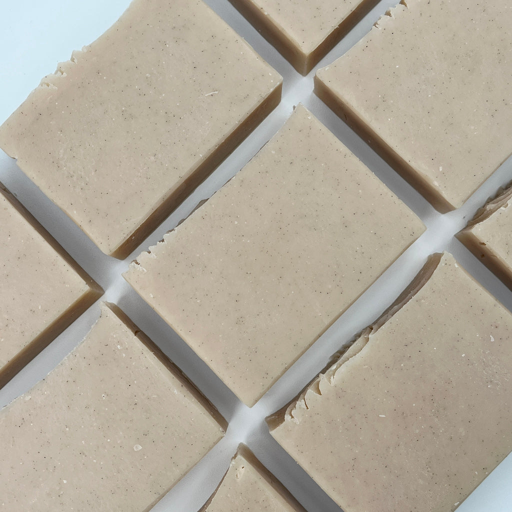 Multiple bars of exfoliating Sandy Shores soap bars laying on a white surface.