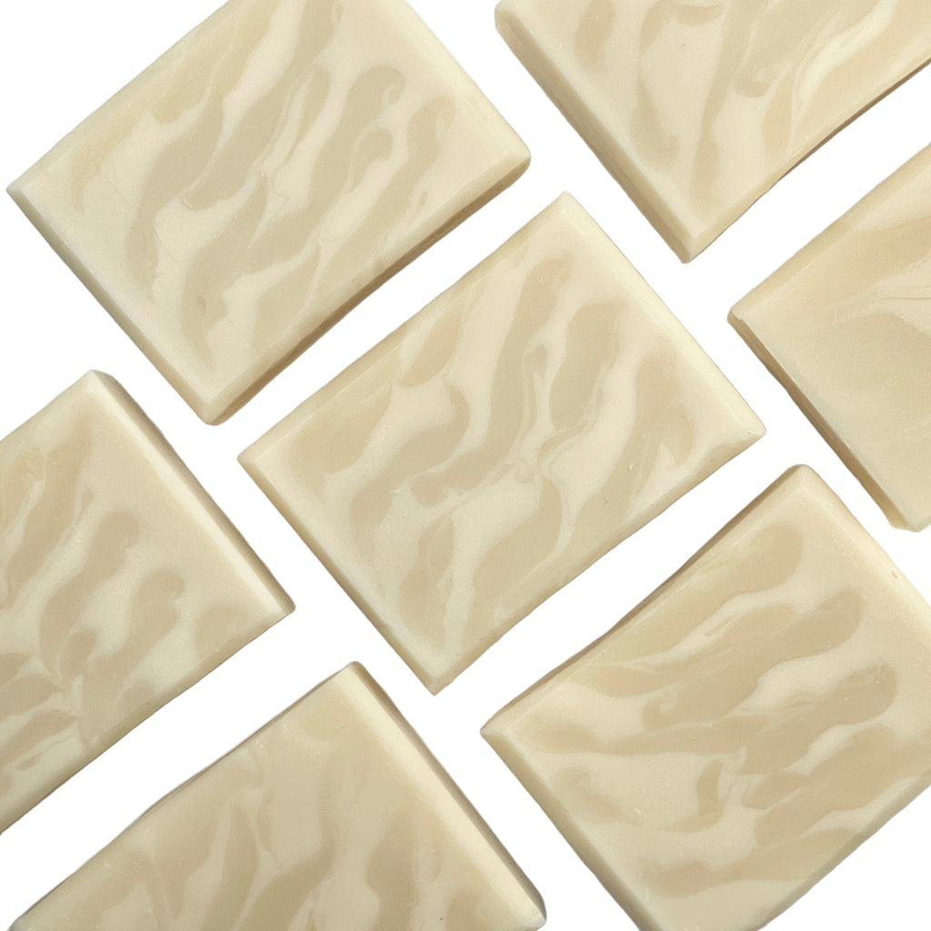 Multiple bars of Skinny Dip unscented soap showing a ghost swirl design on a white surface.