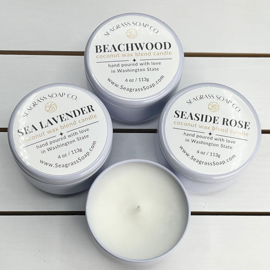 Our Coastal Candle Collection includes beachwood, lavender and seaside rose scents in 4oz white travel tins.