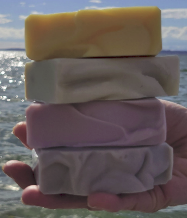 A hand holding 4 soap bars