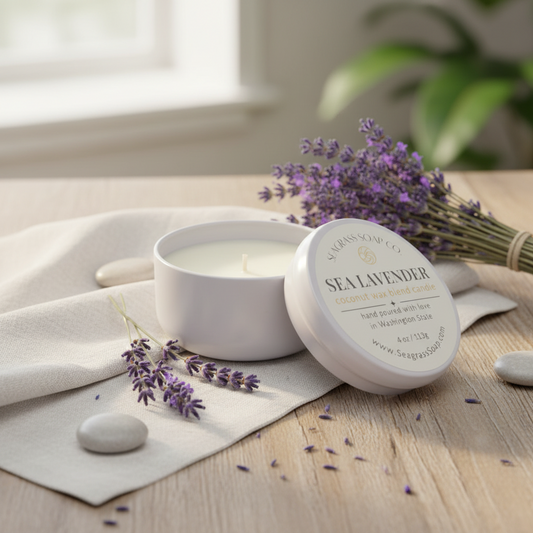 A lavender scented candle on a wooden table surrounding by lavender buds