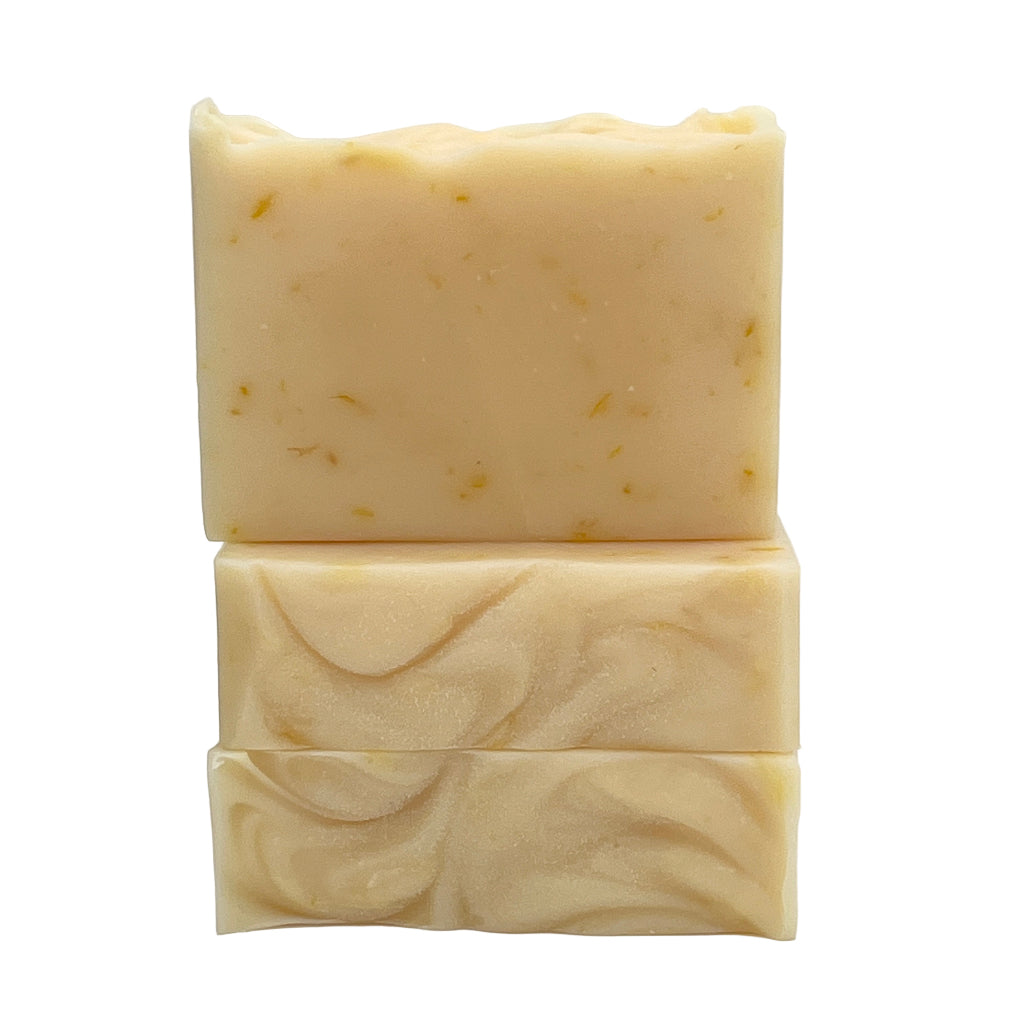 Two bars of lavender lemongrass soap infused with calendula oil and petals on a white background