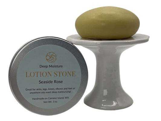 Our Seaside Rose lotion stone sitting on a pedestal next to a tin container