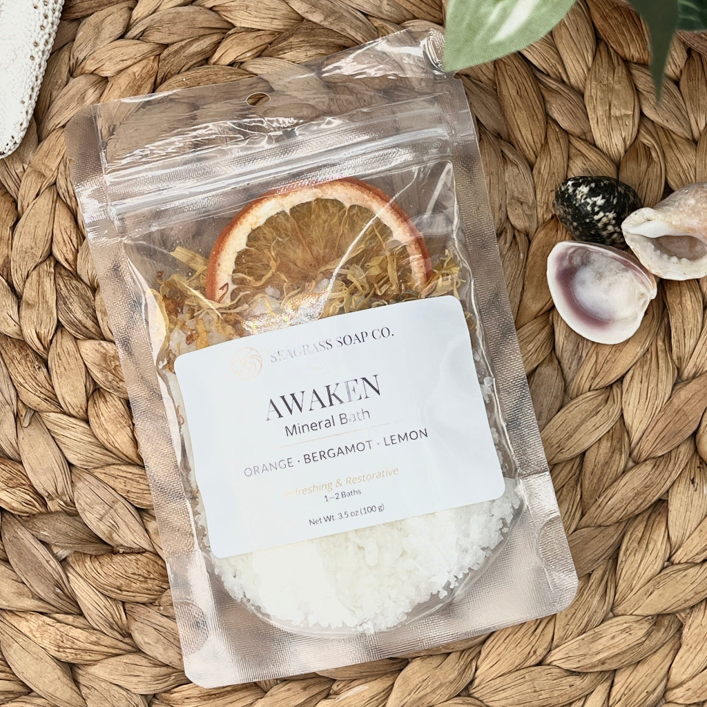 Mineral bath salt package on a woven surface with dried orange slice.