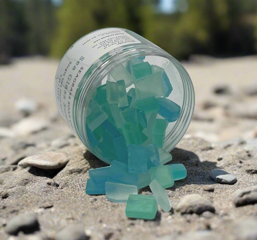 A jar of faux seaglass individual hand soaps laying on its side showcasing the mini soaps.