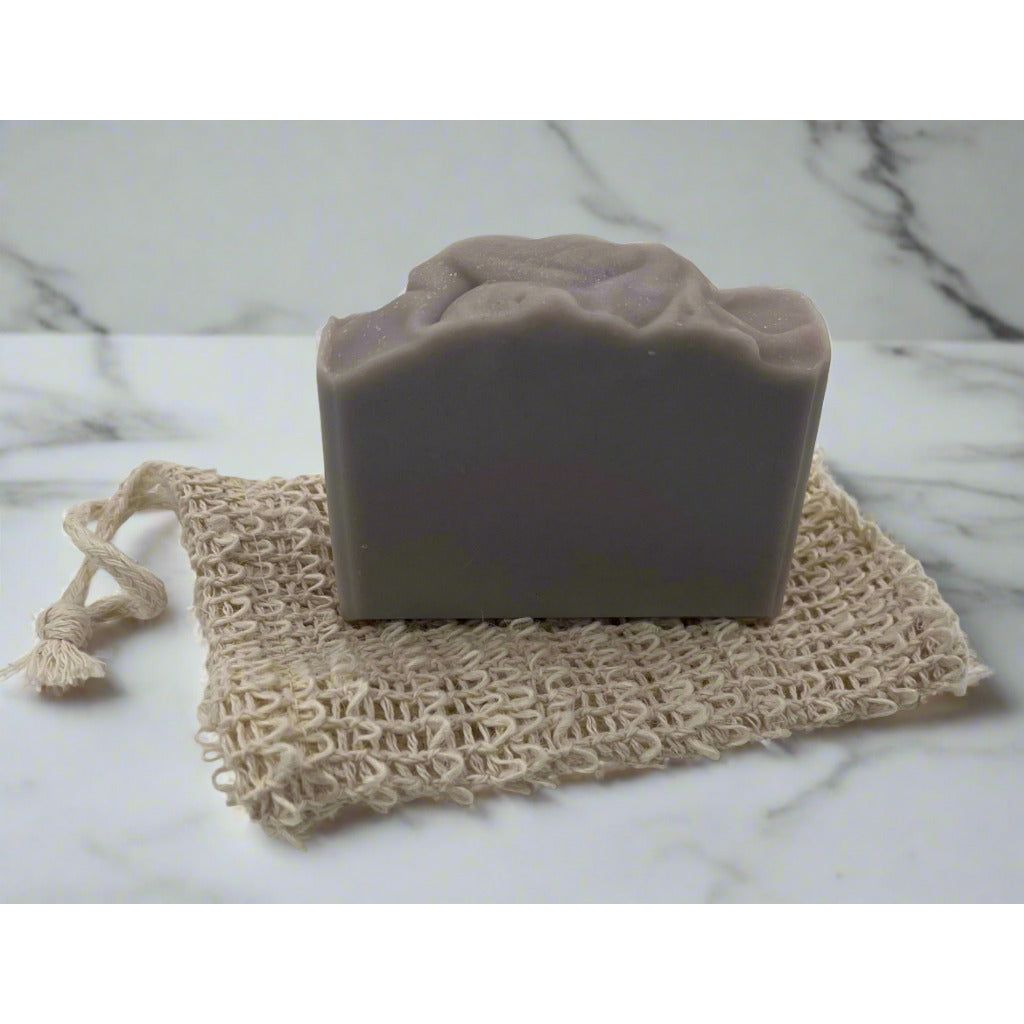 Soap bar sitting on top of a sisal soap bag showing the size of the bag in respect to the bar soap