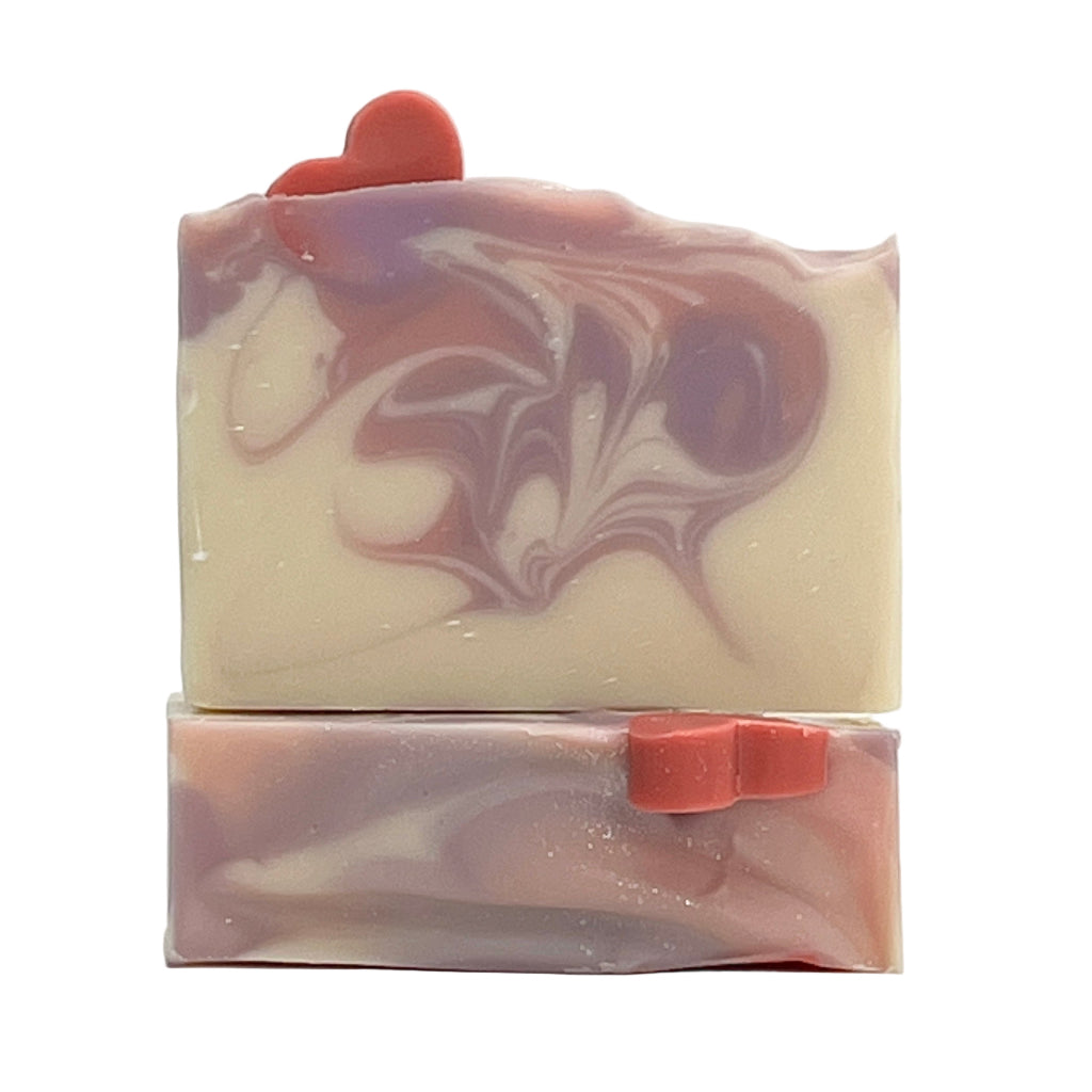 Waves of Love soap with a soap heart on top of a white base bar with pink and purple swirl design on a white background.